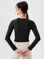 Black long sleeve crop top with mesh panels and crew neck.