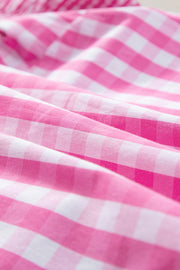 Fuchsia pink and white gingham blouse with ruffle sleeves.