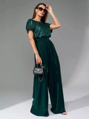 Dark green sequin wide-leg jumpsuit with tie waist and short sleeves.
