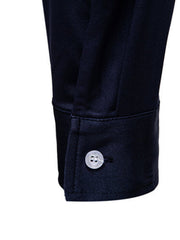 Men's navy blue button-up shirt cuff detail with white button.