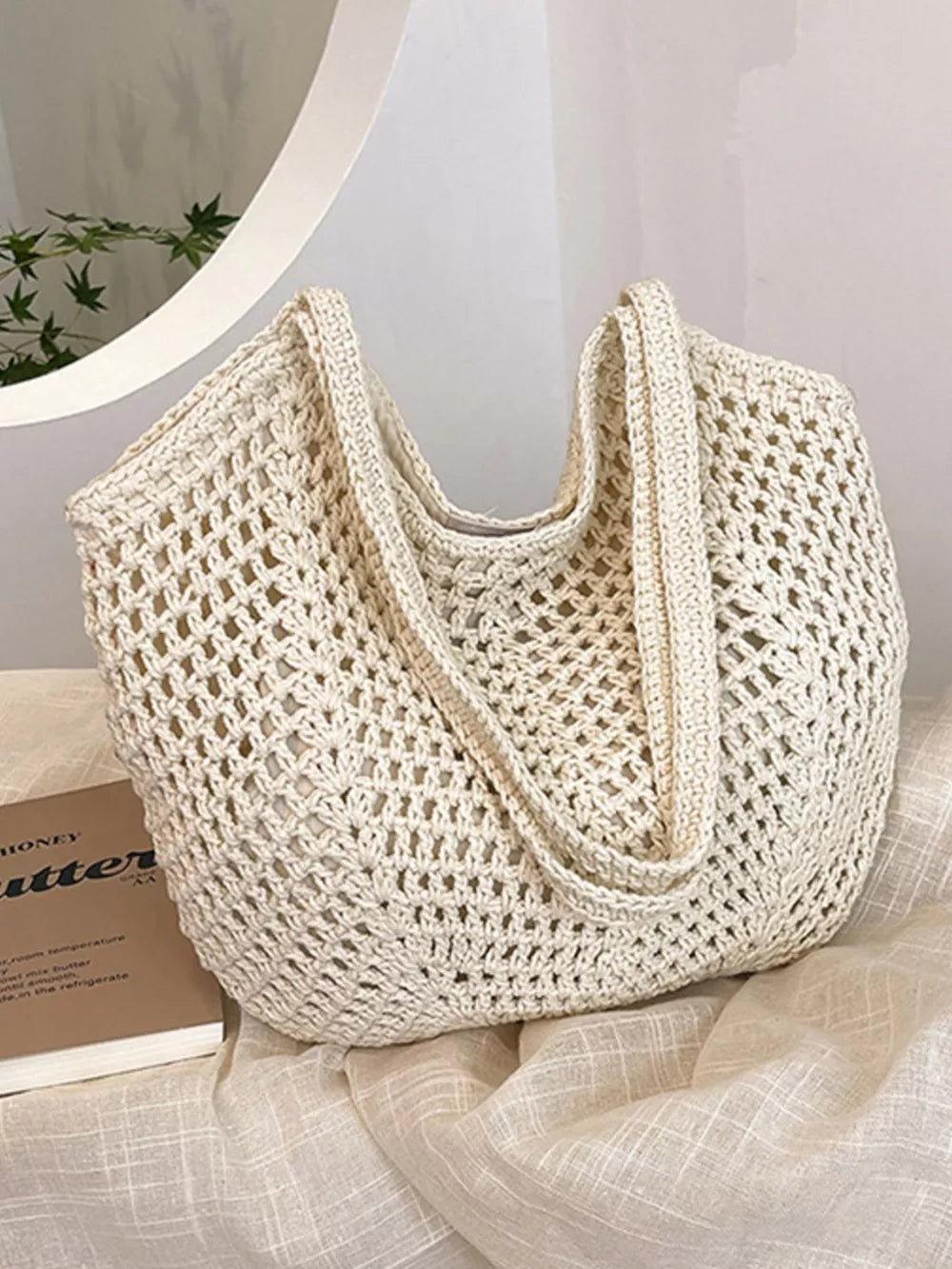 Rice white woven straw shoulder bag with open crochet pattern and braided straps.