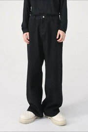 Black wide-leg denim jeans with a relaxed fit, styled with a black top and quilted shoes.