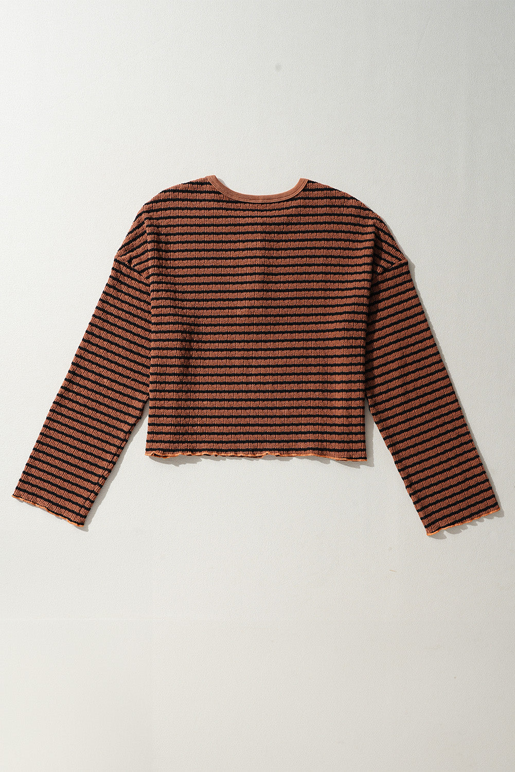Textured henley stripe knit top in caramel with black stripes and lettuce hem detail.