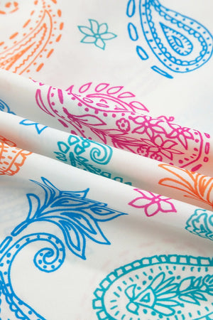 White maternity blouse with vibrant paisley print in pink, blue, and orange.