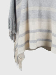 Striped fringe poncho in ivory and charcoal with a relaxed drape.