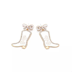 White cowboy boot dangle earrings with "Bride" text, crystal trim, and bow detail.