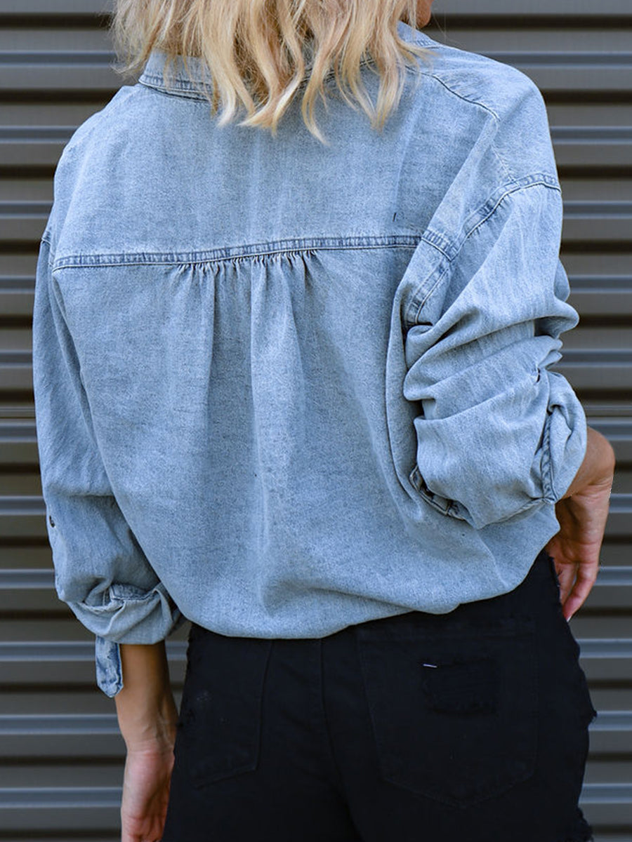 Light denim blouson shirt with buttoned cuffs and gathered back detail.