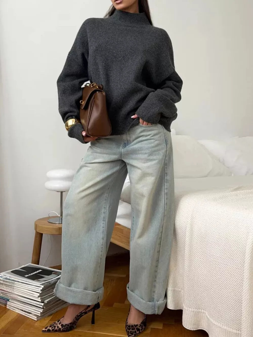 Relaxed mock neck sweater in dark gray acrylic blend with cuffed sleeves, styled with light wash jeans and leopard print