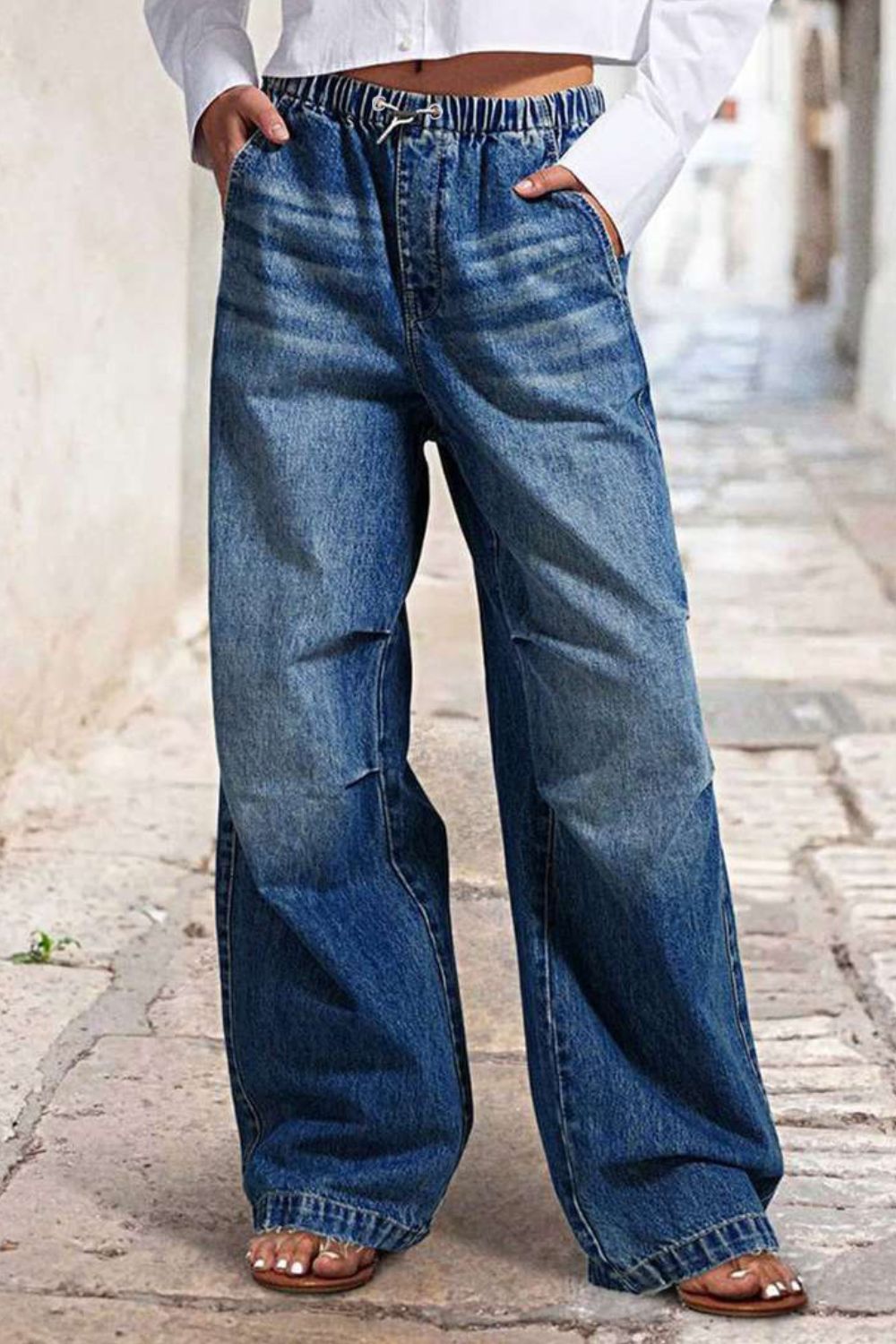 Elastic waist palazzo jeans in medium wash denim with a drawstring and wide leg.