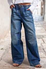 Elastic waist palazzo jeans in medium wash denim with a drawstring and wide leg.