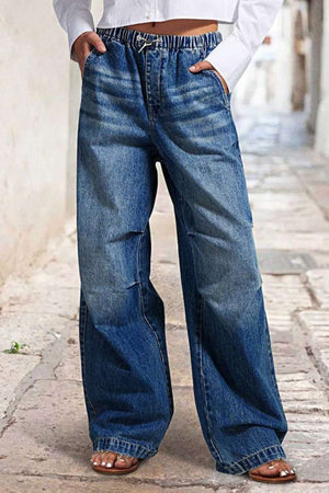 Elastic waist palazzo jeans in medium wash denim with a drawstring and wide leg.