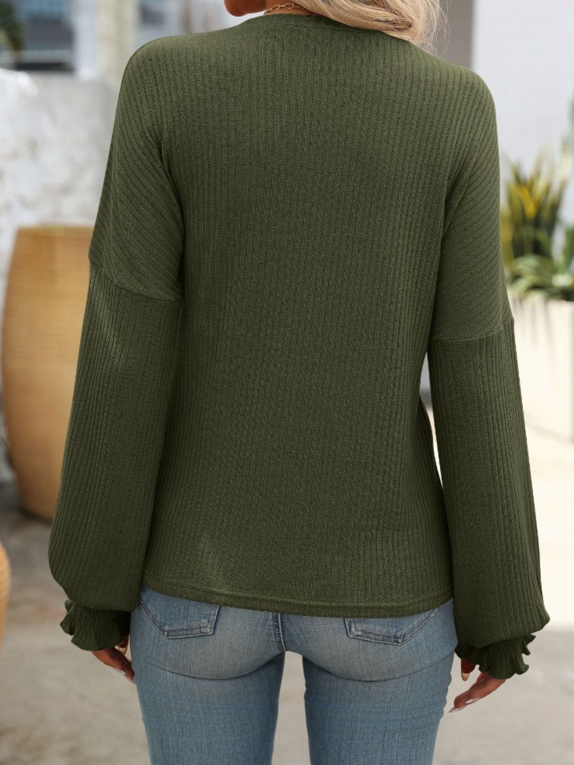 Army green ribbed knit blouse with ruffled cuffs and long sleeves.
