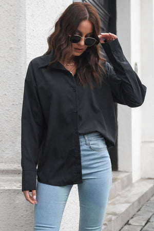 Oversized black cotton poplin shirt with button front and collar, styled with light wash jeans.