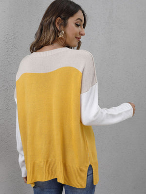 Colorblock crewneck knit sweater in yellow, cream, and white with side slits.