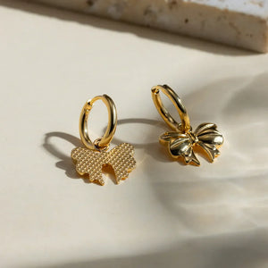 Gold hoop earrings with detailed bow charms, 18K gold-plated.