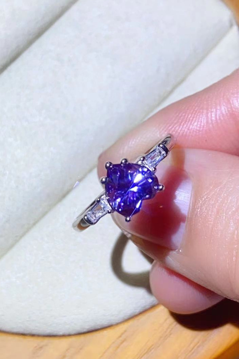 Purple heart-cut moissanite ring with baguette accents in platinum.