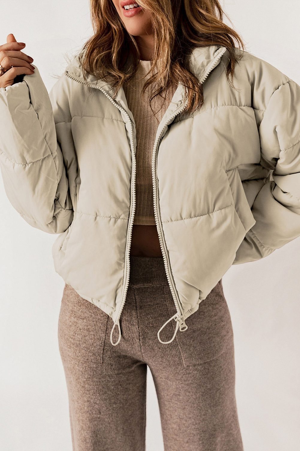 Taupe cropped puffer jacket with hood, full zip, and drawstring hem.