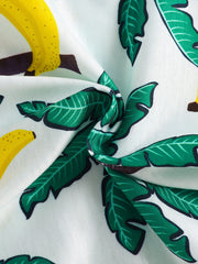 Baby set with tropical palm and banana print in white cotton, featuring a drawstring detail.