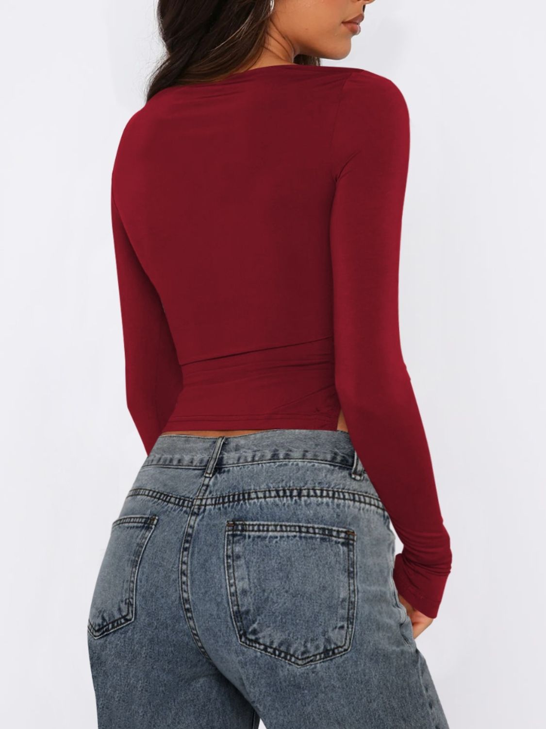 Burgundy long sleeve ruched top with adjustable side tie detail.
