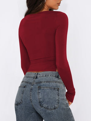 Burgundy long sleeve ruched top with adjustable side tie detail.