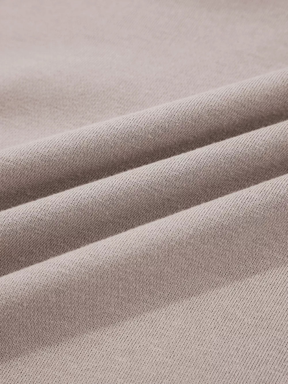 Multi-tonal relaxed fit cotton hoodie in a soft taupe color, showing fabric texture.