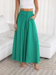 Textured drawstring palazzo trousers in green with pockets and a cinched waist.