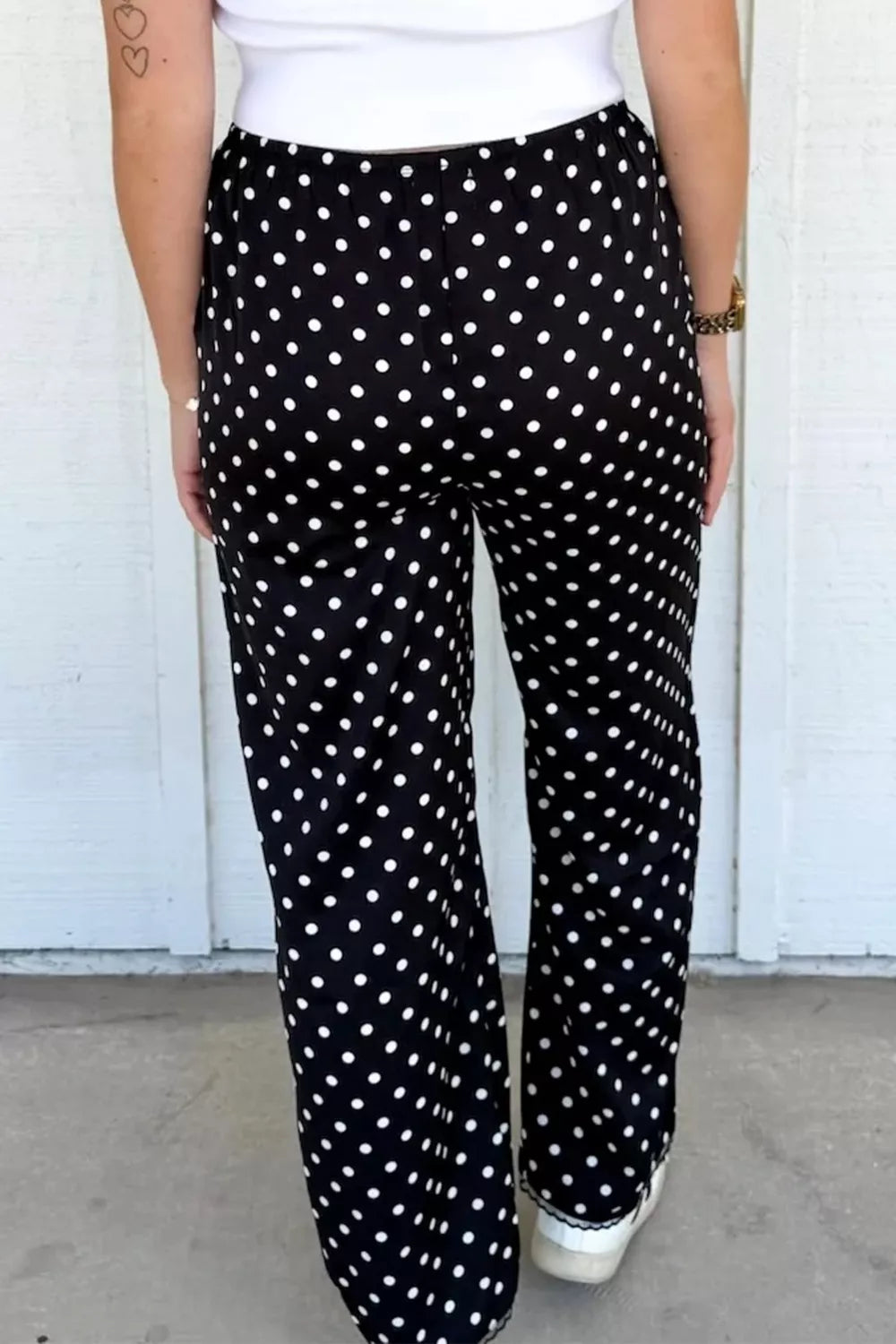 Black polka dot wide-leg maternity trousers with an elastic waistband.