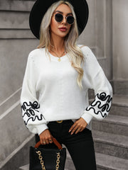 White voluminous knit sweater with embroidered sleeves and V-neck