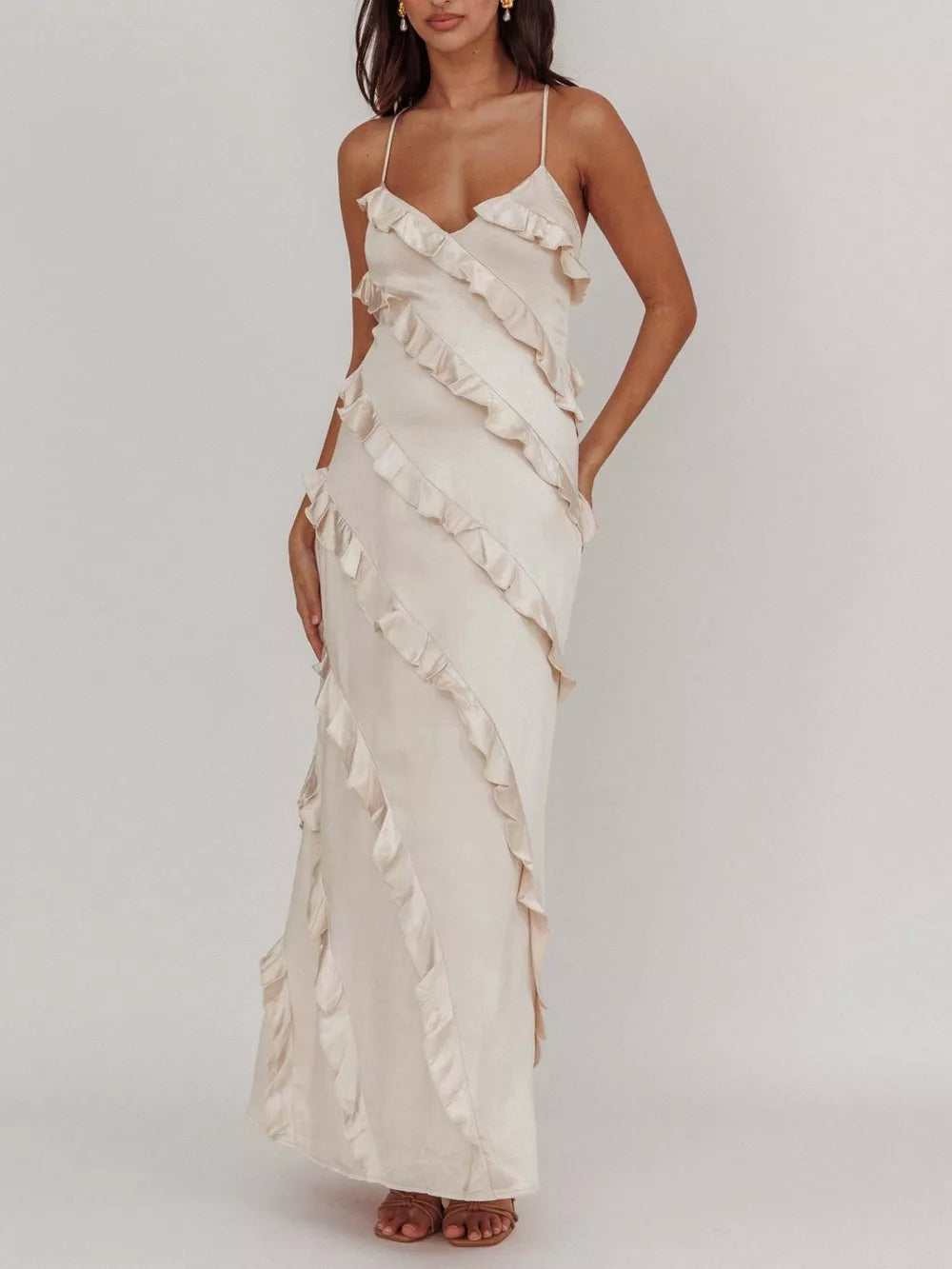 Beige ruffled spaghetti strap maxi dress with diagonal ruffle detailing.