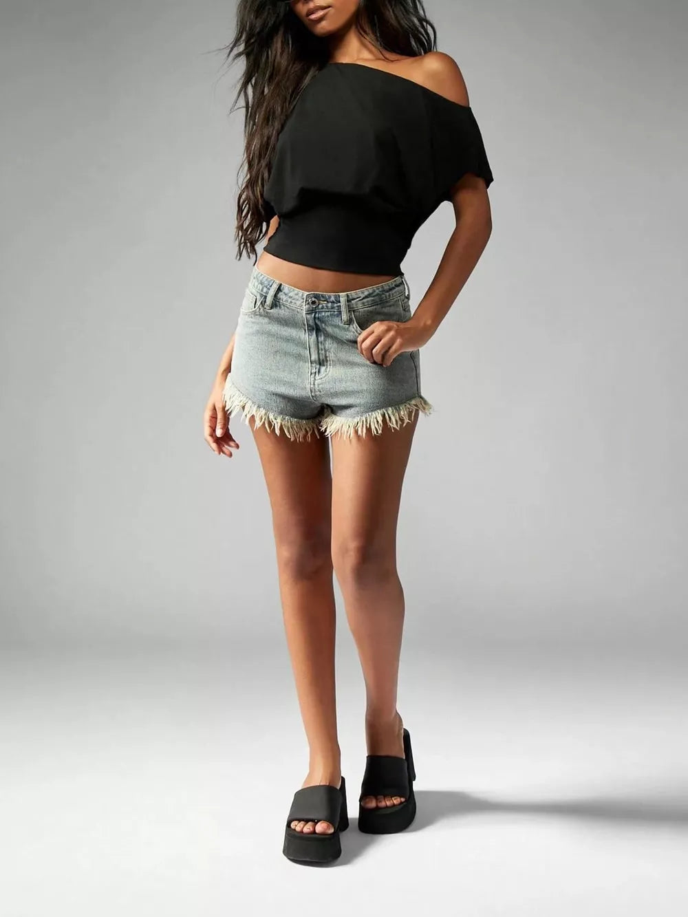 Black asymmetrical crop t-shirt with draped fit and off-the-shoulder neckline.