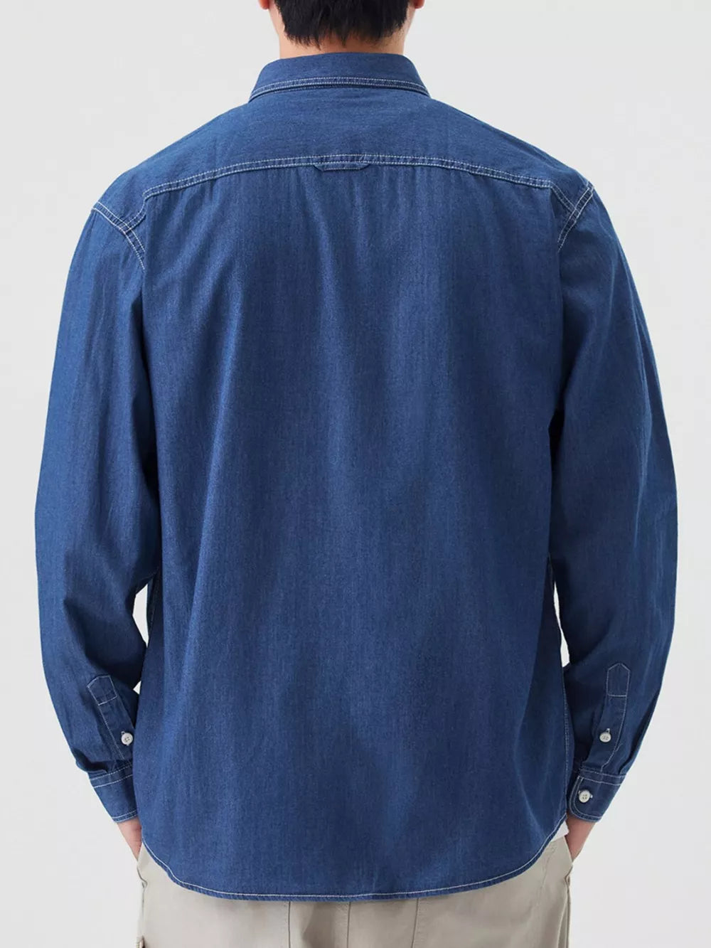 Blue denim button-up shirt with chest pockets and white contrast stitching.