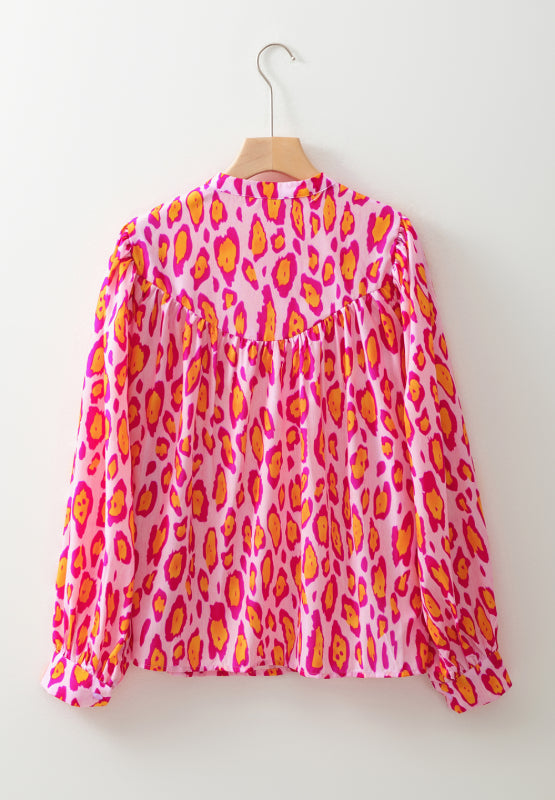 Pink leopard print blouse with balloon sleeves and a mock neck.