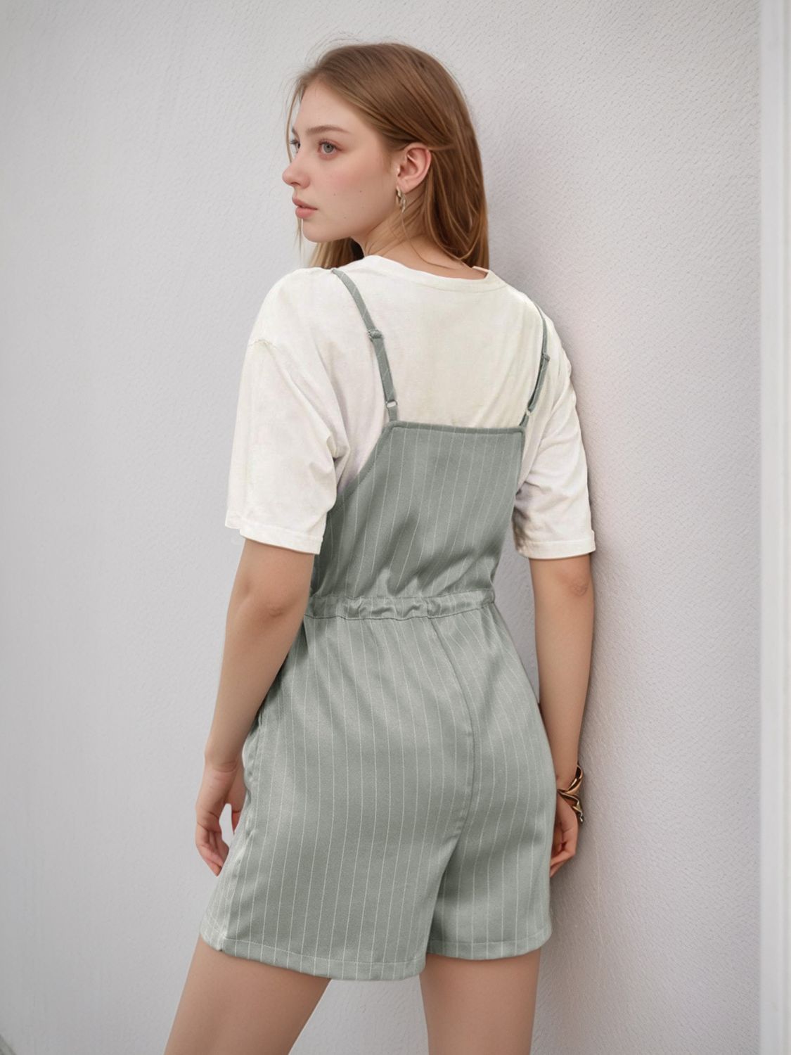 Sage pinstripe romper with adjustable waist, styled with a white t-shirt.