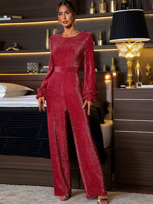 Deep red shimmer jumpsuit with ruffled long sleeves and wide legs.