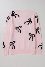 Blush pink knit crewneck sweater with allover black bow motifs.