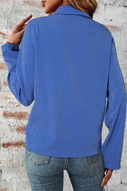 Dusty blue utility-inspired blouse with long sleeves and a collared neckline, shown from the back.