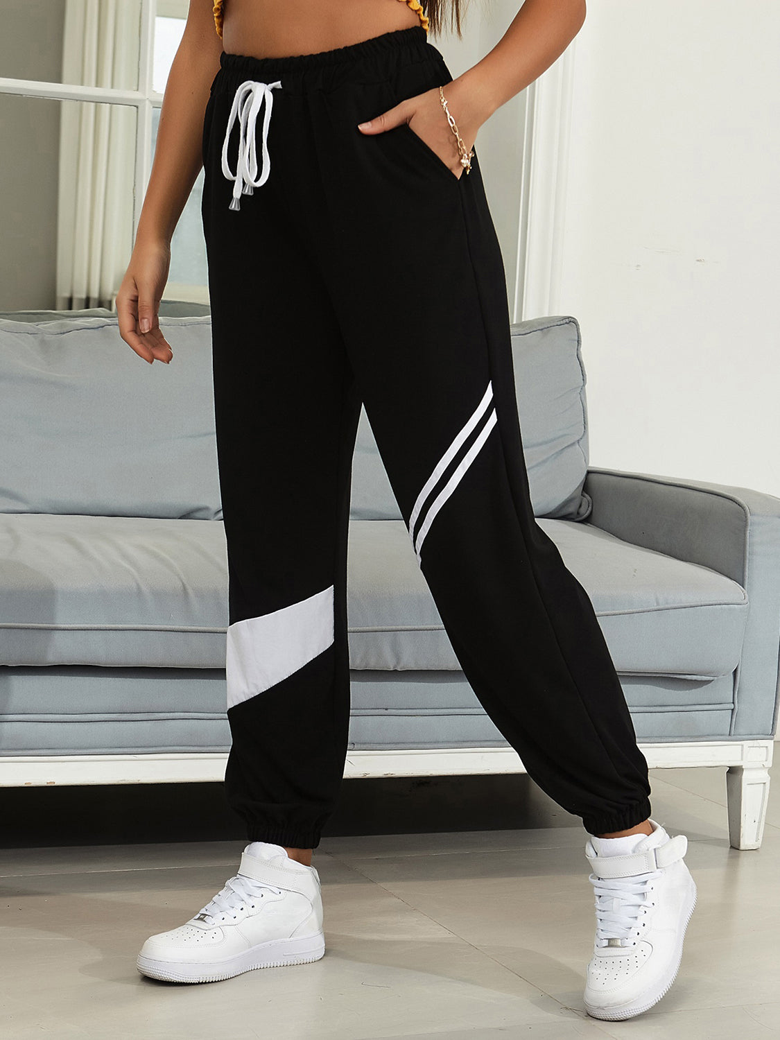 Black joggers with drawstring waist and diagonal white panel details