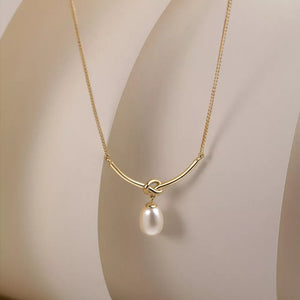 Gold necklace with knot detail and lustrous pearl pendant