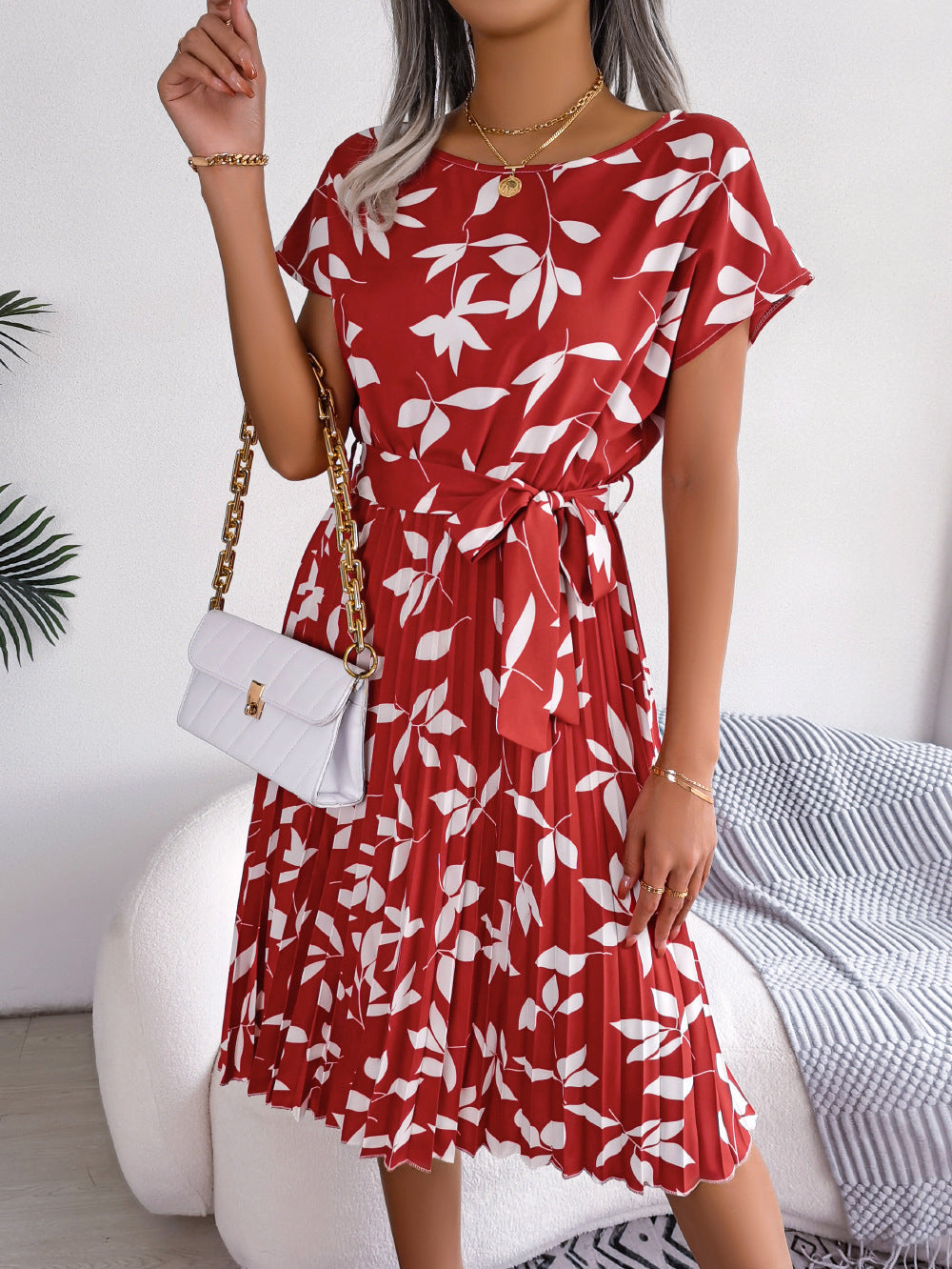 Crimson leaf print midi dress with tie waist and pleated skirt.