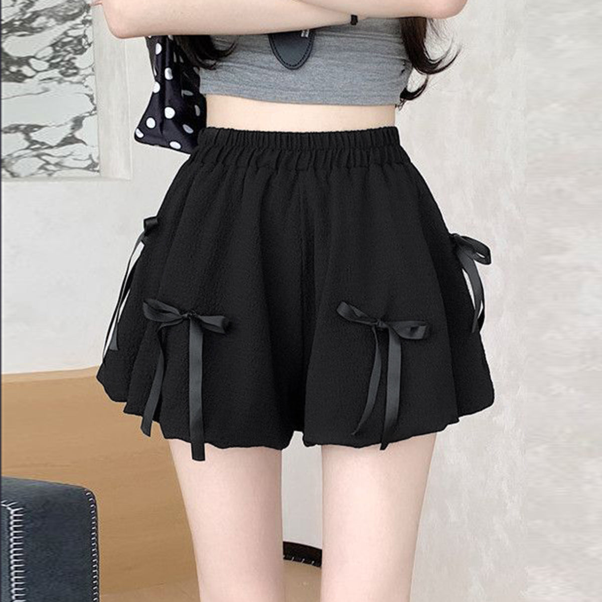 Black high waist bubble skirt with bowknot details and elastic waistband.