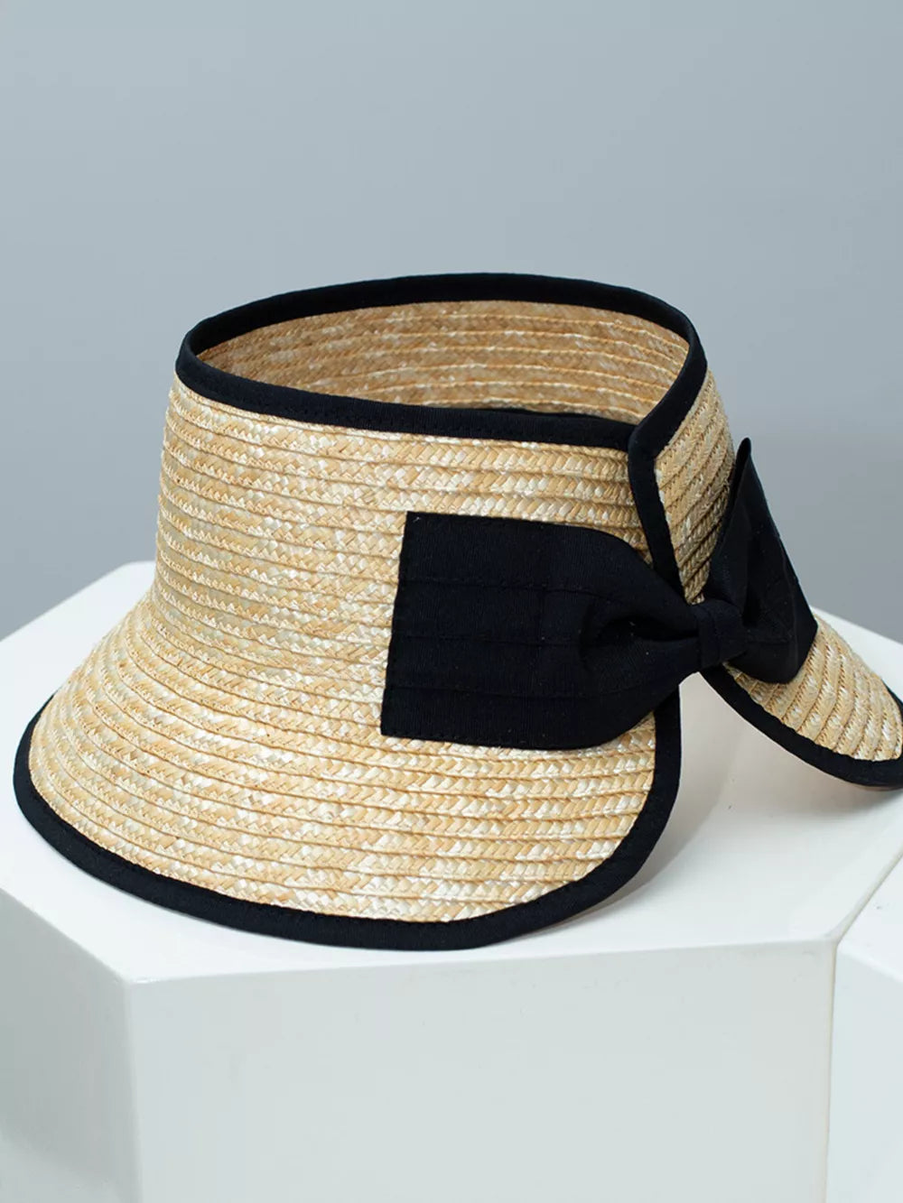 Straw visor hat with black trim and bow detail