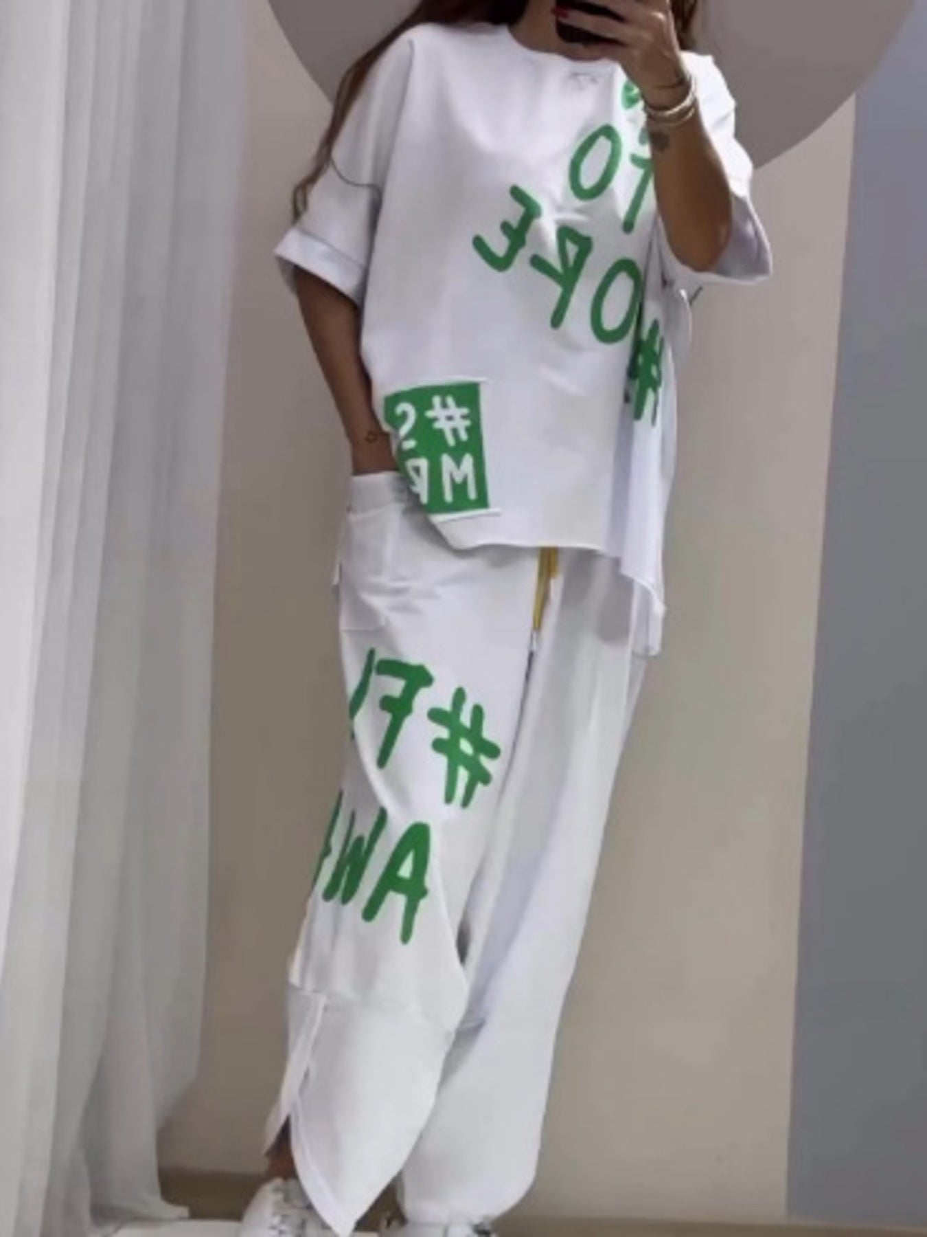 White graphic tee and drawstring pants set with bold green lettering and numbers.