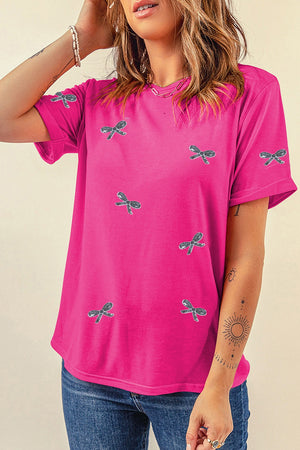 Hot pink t-shirt with all-over embroidered bow pattern and rolled sleeves.