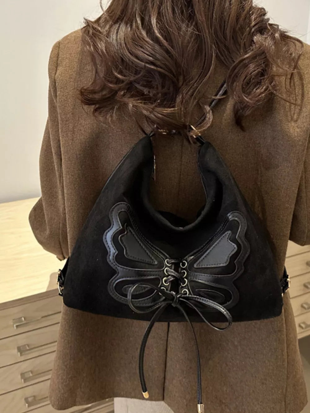 Black suede half-moon bag with butterfly lace-up detail