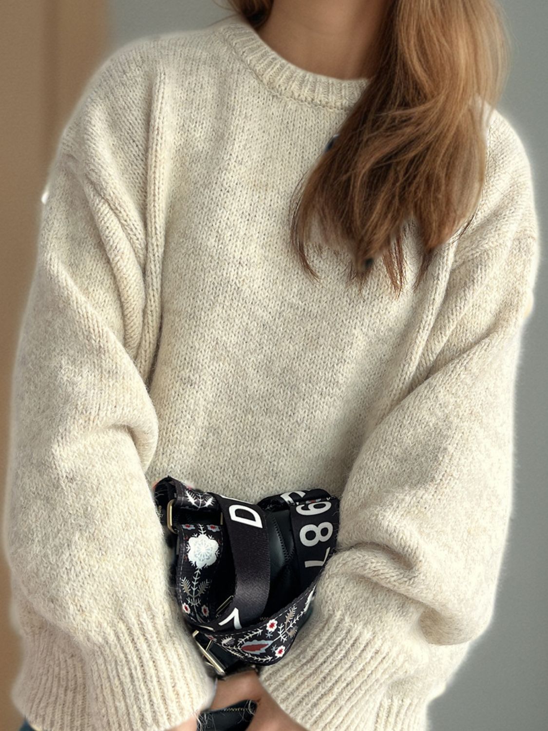 Oversized beige crewneck sweater with textured knit and ribbed cuffs.