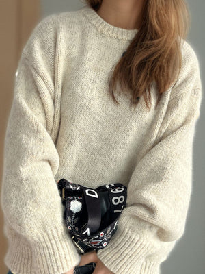 Oversized beige crewneck sweater with textured knit and ribbed cuffs.