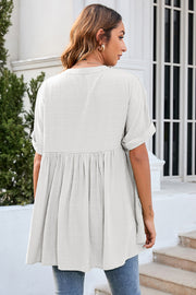 White gathered back yoke blouse with rolled sleeves and a flowy hem.