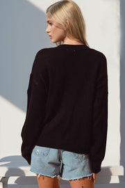 Black V-neck cardigan with embroidered pumpkin patch detail, 100% polyester.