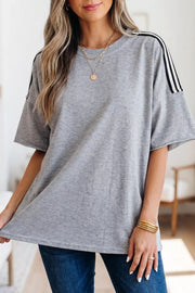 Grey relaxed fit t-shirt with black and white shoulder stripes, short sleeves, and polyester fabric.
