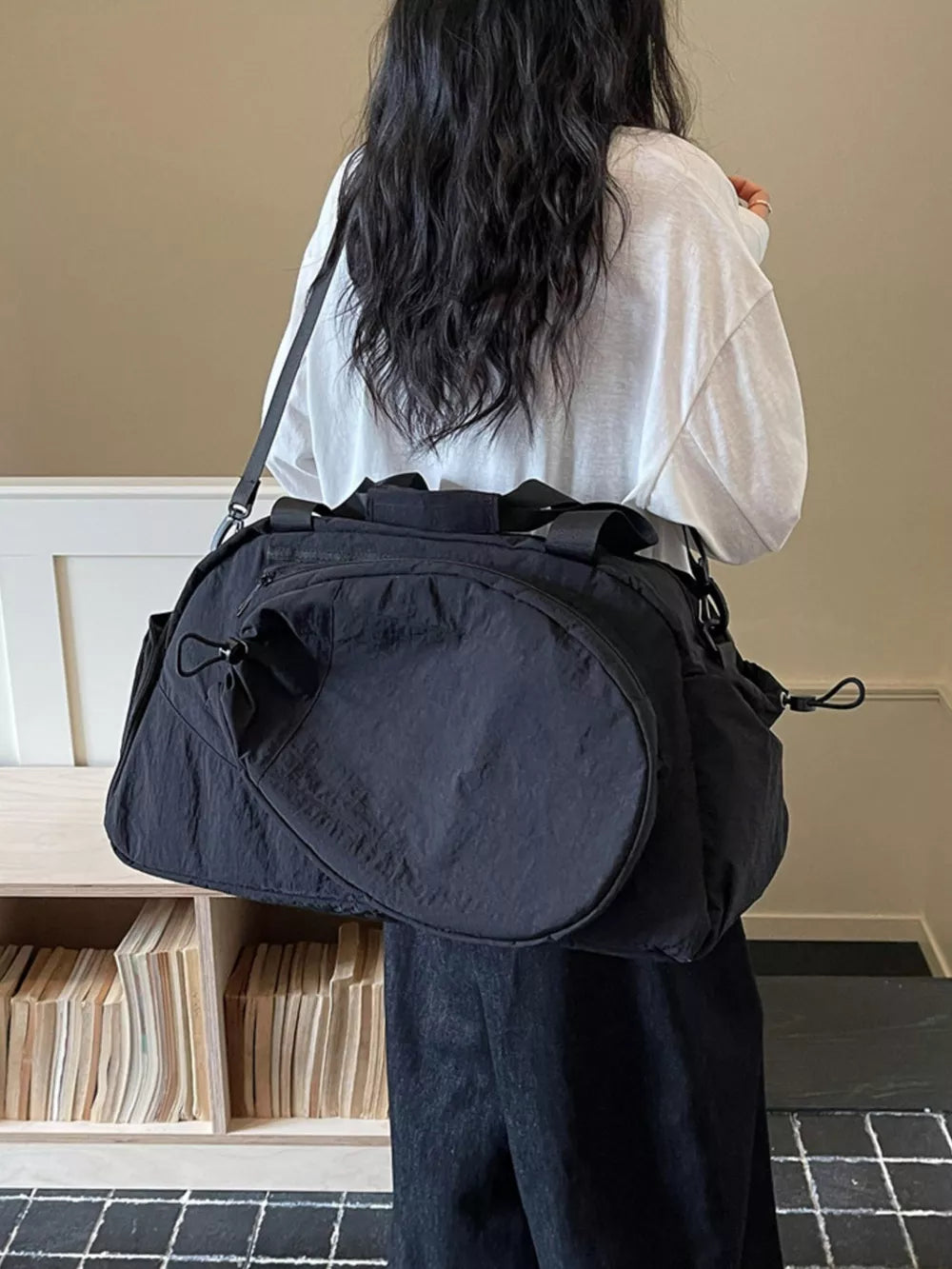Black nylon sport duffle bag with adjustable strap and side pocket detail.